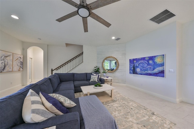 tiled living area featuring visible vents, stairs, recessed lighting, a ceiling fan, and arched walkways