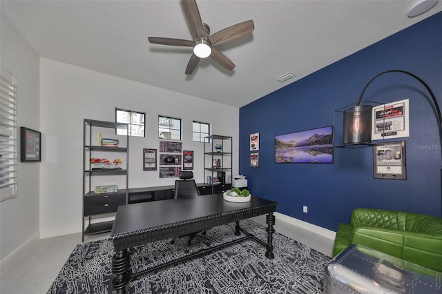 office with baseboards, visible vents, and a ceiling fan