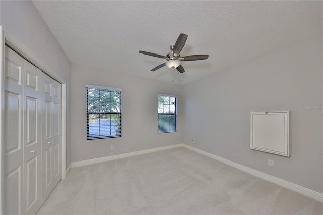 unfurnished bedroom featuring a closet, baseboards, and light colored carpet