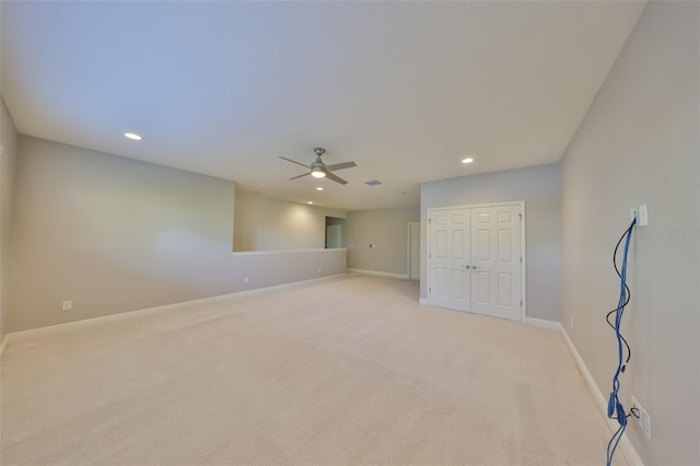empty room with a ceiling fan, light carpet, baseboards, and recessed lighting