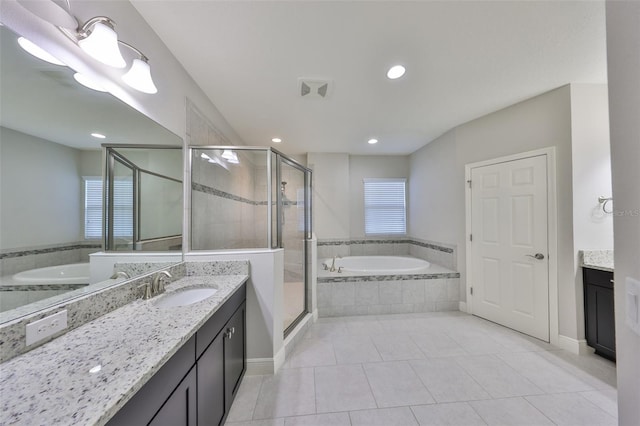 bathroom with tile patterned flooring, vanity, a garden tub, and a shower stall