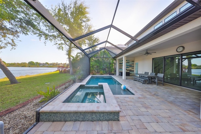 outdoor pool featuring glass enclosure, a water view, an in ground hot tub, and ceiling fan