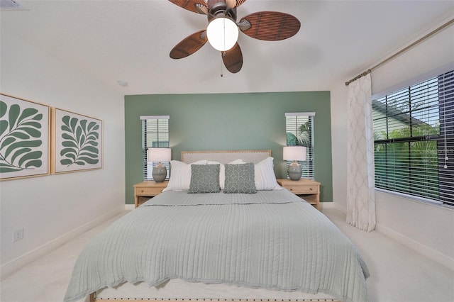 bedroom with multiple windows, ceiling fan, carpet floors, and baseboards