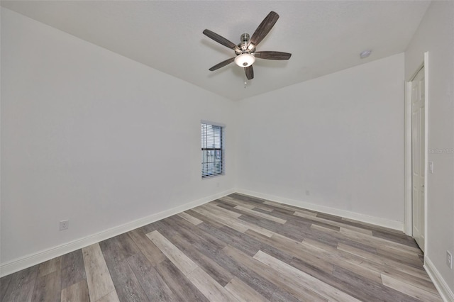 spare room with baseboards, ceiling fan, and wood finished floors