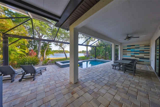 view of swimming pool with a water view, a pool with connected hot tub, a lanai, a patio, and a ceiling fan