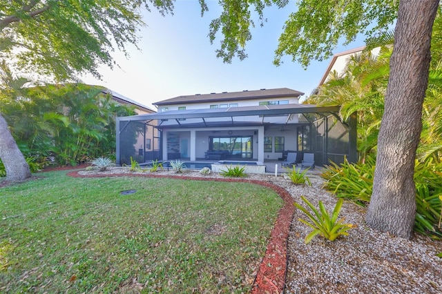 rear view of property with glass enclosure, stucco siding, a patio, and a yard