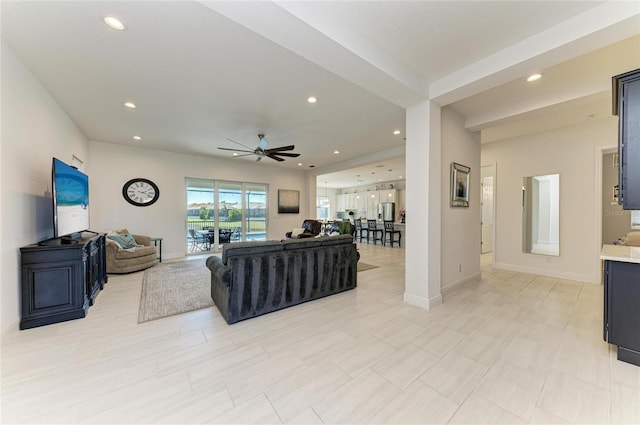 living room with baseboards, a ceiling fan, and recessed lighting