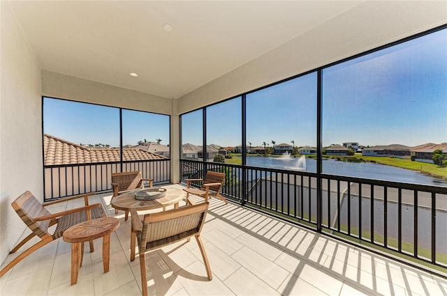 sunroom / solarium featuring a water view