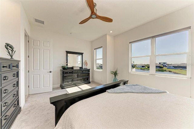 bedroom featuring light carpet, ceiling fan, visible vents, and baseboards