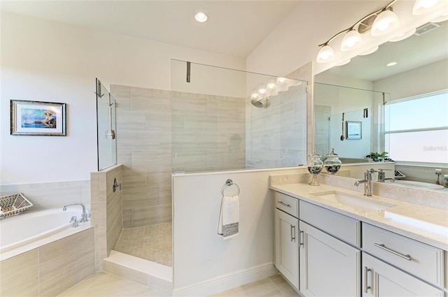 bathroom with a garden tub, tile patterned flooring, tiled shower, and vanity