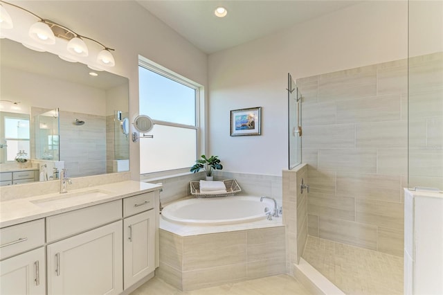 bathroom with recessed lighting, vanity, a bath, and walk in shower