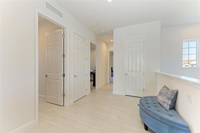 hallway featuring visible vents and baseboards