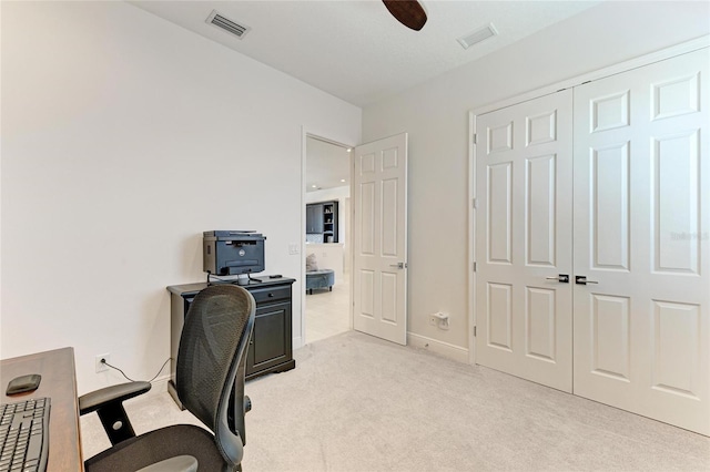 home office featuring ceiling fan, visible vents, baseboards, and light colored carpet