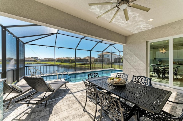 view of patio with ceiling fan, a lanai, a water view, an outdoor pool, and outdoor dining space