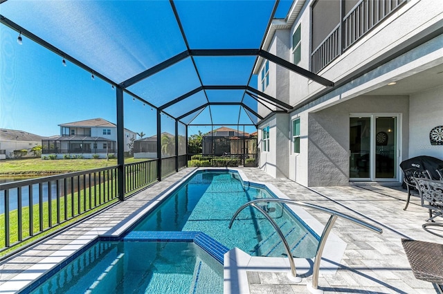 view of pool featuring a pool with connected hot tub, a patio area, a lanai, and a residential view