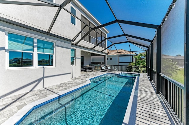 view of pool featuring a lanai, a patio area, a pool with connected hot tub, and a ceiling fan