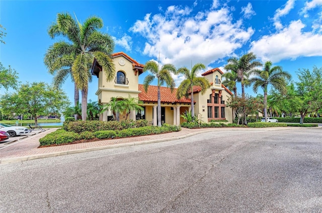 mediterranean / spanish house featuring a tiled roof and stucco siding