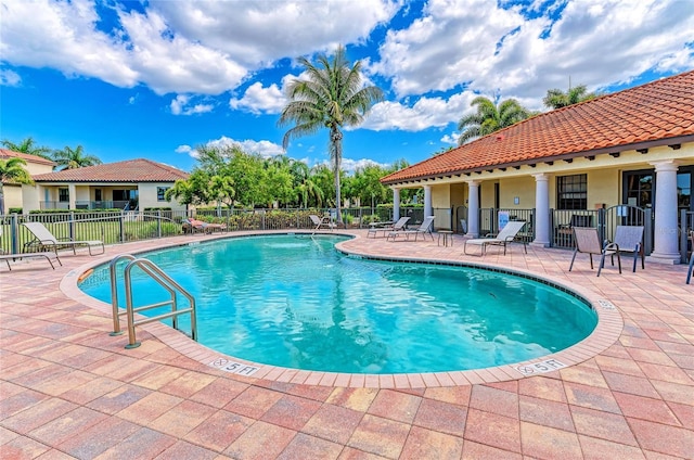 pool featuring fence and a patio