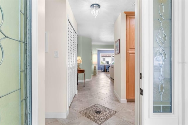 foyer entrance featuring light tile patterned flooring and baseboards