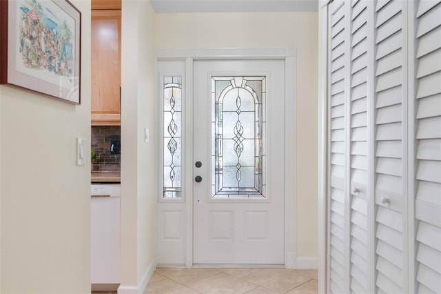 foyer entrance with light tile patterned flooring, a wealth of natural light, and baseboards