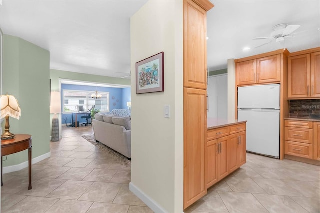 hallway with light tile patterned floors, baseboards, and a notable chandelier