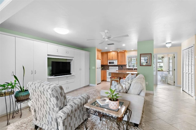 living area with ceiling fan, recessed lighting, light tile patterned flooring, and baseboards