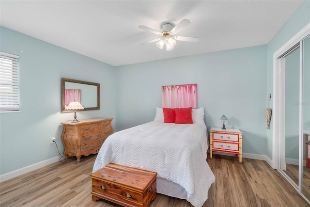 bedroom with a ceiling fan, a closet, baseboards, and wood finished floors