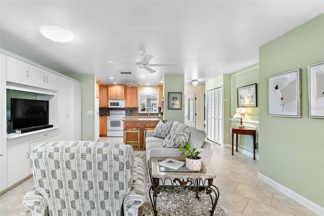 living area featuring light tile patterned floors, ceiling fan, baseboards, and recessed lighting