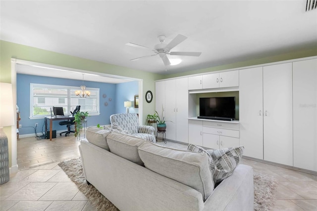 living room with light tile patterned floors, visible vents, baseboards, and ceiling fan with notable chandelier