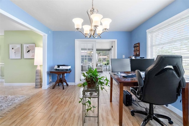 office area featuring baseboards, a notable chandelier, and wood finished floors