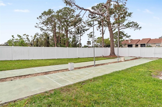 view of yard with fence and shuffleboard