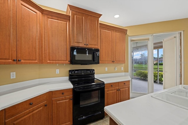 kitchen with brown cabinetry, recessed lighting, light countertops, and black appliances