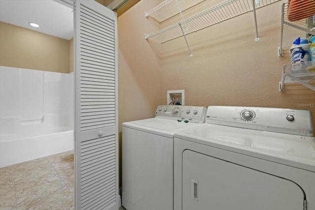 laundry room with laundry area, light tile patterned flooring, and washer and dryer