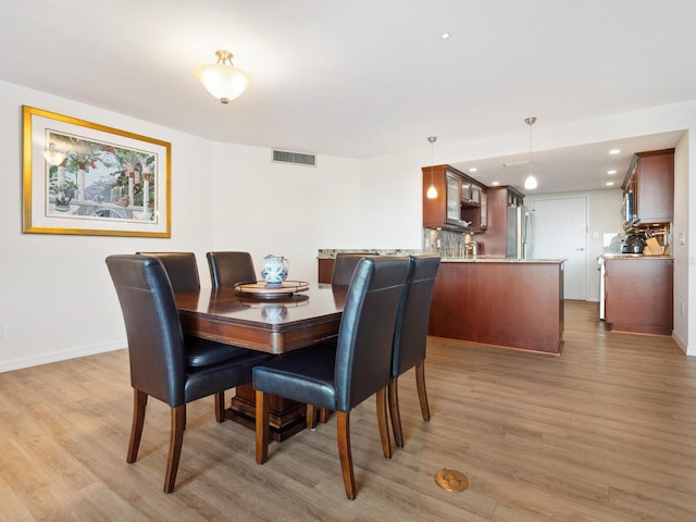 dining room with light wood-style floors, baseboards, visible vents, and recessed lighting