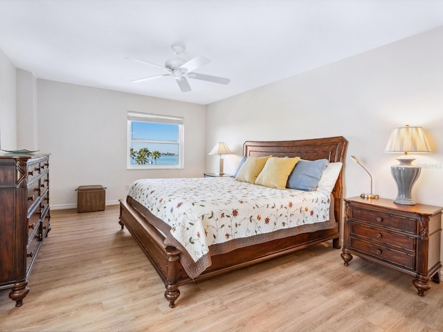 bedroom with light wood-style flooring, baseboards, and a ceiling fan