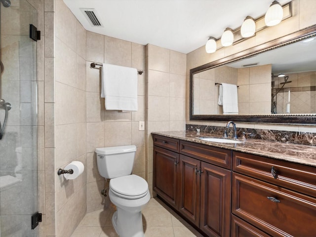 full bathroom featuring tile walls, visible vents, a stall shower, vanity, and tile patterned floors