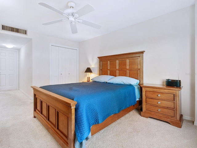 bedroom with ceiling fan, light carpet, visible vents, baseboards, and a closet