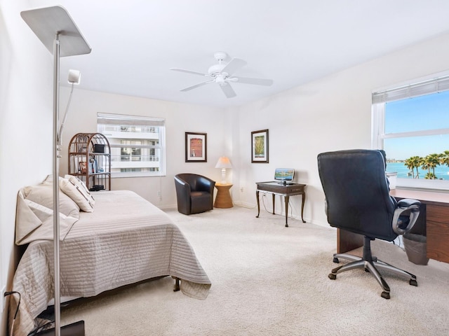 carpeted bedroom with ceiling fan and baseboards