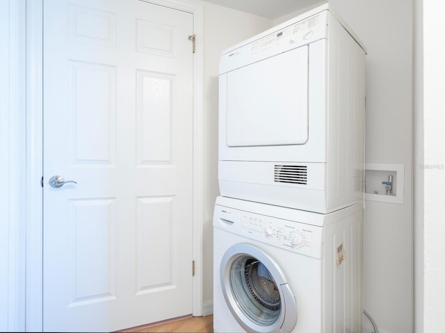 laundry room with stacked washer and clothes dryer and laundry area