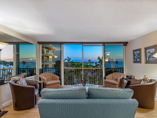 living room with expansive windows, baseboards, and light wood finished floors