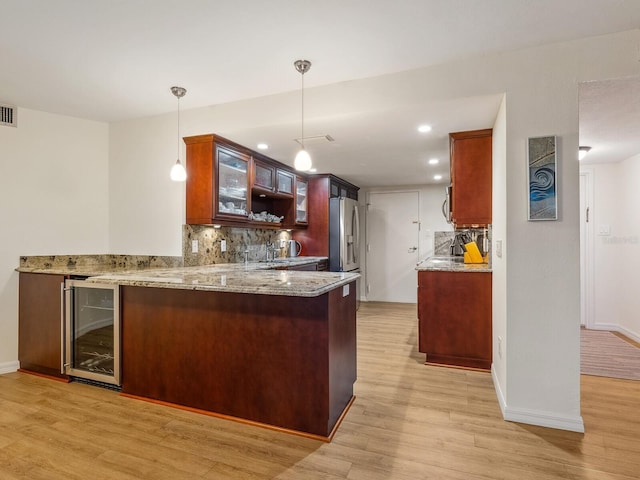 kitchen with wine cooler, backsplash, appliances with stainless steel finishes, and light wood-style floors