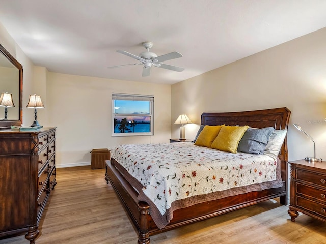 bedroom with a ceiling fan, baseboards, and wood finished floors