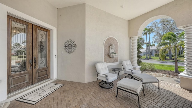 property entrance with stucco siding and french doors