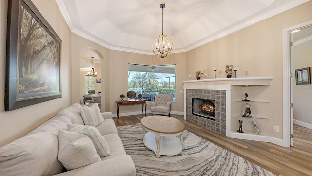 6621 The Masters Ave, Lakewood Ranch, FL 34202 - living area featuring a chandelier, ornamental molding, wood finished floors, a tile fireplace, and baseboards