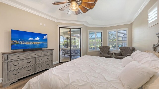 6621 The Masters Ave, Lakewood Ranch, FL 34202 - bedroom with access to exterior, crown molding, multiple windows, wood finished floors, and baseboards