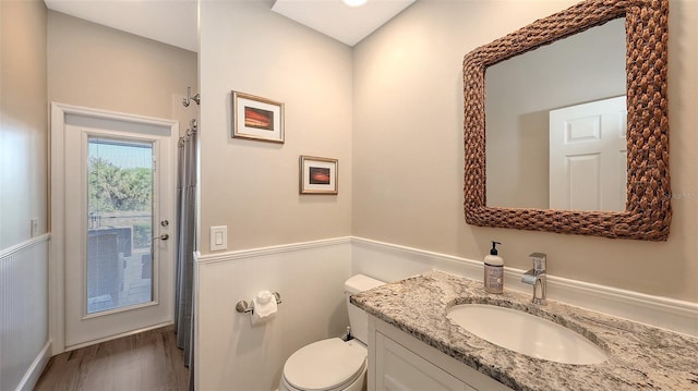6621 The Masters Ave, Lakewood Ranch, FL 34202 - bathroom with wainscoting, vanity, toilet, wood finished floors, and a shower