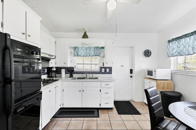 2564 Wood St, Sarasota, FL 34237 - kitchen with light countertops, backsplash, a sink, under cabinet range hood, and black appliances
