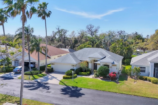 mediterranean / spanish home featuring a garage, driveway, and a front lawn