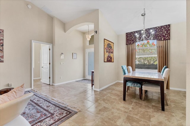 dining space with high vaulted ceiling, baseboards, a chandelier, and arched walkways