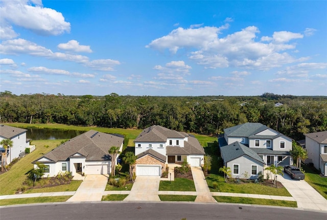 drone / aerial view featuring a wooded view and a residential view